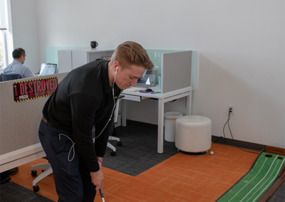 Practicing putt putt golf at the office.